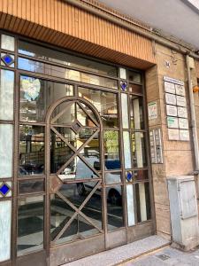 een deur van een winkel met een reflectie van een auto erin bij Suite 84 Holiday Home in Salerno