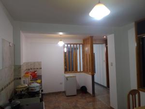 cocina con paredes blancas, encimera y luz en Departamento luxor en Cajamarca