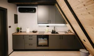 a kitchen with a sink and a stove at Pinery Blidinje A-Frame House in Blidinje