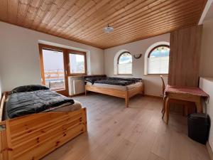 een slaapkamer met twee bedden en twee ramen bij Apartment Lopez in Sankt Johann in Tirol