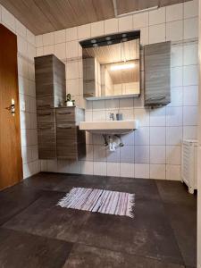 een keuken met een wastafel, een spiegel en een aanrecht bij Apartment Lopez in Sankt Johann in Tirol