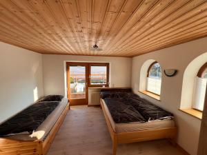 twee bedden in een kamer met een houten plafond bij Apartment Lopez in Sankt Johann in Tirol