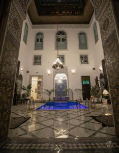 a lobby with a fountain in the middle of a building at Palais Chahd Luxury in Fez