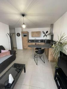 a living room with a couch and a table at Appart. sur Caen avec Garage et Wifi. in Caen