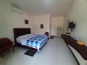 a bedroom with a bed and a tv in it at Puri Kesumayudha House 2 in Tanjungkarang
