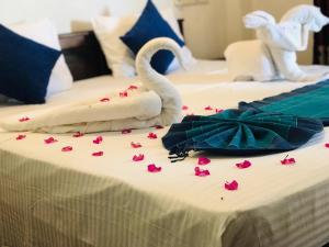 two beds with pink rose petals on the bed at Tamaro Beach Resort in Hikkaduwa