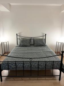 a bed with a black frame and two pillows at Elegant flat - Center of Brussels in Brussels