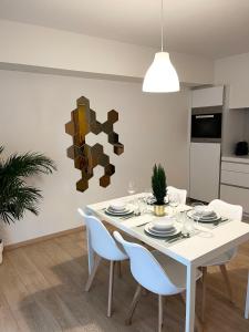 a white dining room with a white table and chairs at Elegant flat - Center of Brussels in Brussels