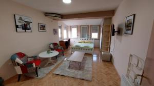 a small room with a bed and a table and chairs at HRISTIJAN APARTMENT in the city center in Štip