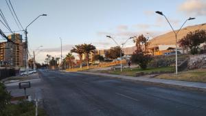 an empty city street with palm trees and buildings at Casa interior Playa Brava in Iquique