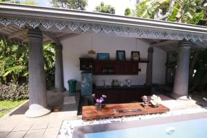 un patio con una mesa y una piscina en Villa Lotus en Hikkaduwa