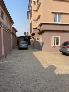ein Auto, das auf einer Straße neben einem Gebäude geparkt ist in der Unterkunft Joda’s apartment in Lagos