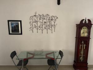 a table and a clock and a glass table and a clock at Joda’s apartment in Lagos