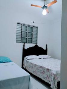 um quarto com 2 camas e uma ventoinha de tecto em Apê Expô/ABQM - Cantinho Moraes em Araçatuba