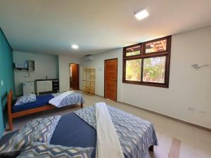 a bedroom with two beds and a window at Suítes Barra da Lagoa in Ubatuba