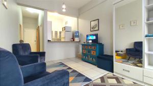 a waiting room with blue chairs and a television at Studio Canadá: Custo-Benefício $ in Florianópolis