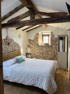 a bedroom with a large bed in a stone wall at DOMUS VELA in Fornelli