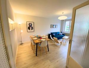 ein Wohnzimmer mit einem Tisch und einem blauen Sofa in der Unterkunft L'Appart' de Famille - 6 pers - Poitiers Centre in Poitiers