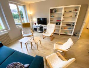 ein Wohnzimmer mit einem blauen Sofa und Stühlen in der Unterkunft L'Appart' de Famille - 6 pers - Poitiers Centre in Poitiers
