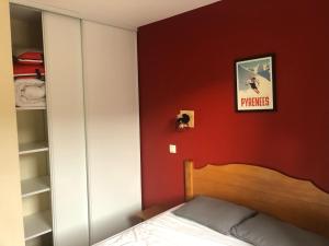a bedroom with a bed and a red wall at Appartement à Saint Lary Soulan, 4-5 pers, à 150m des télécabines et du village in Saint-Lary-Soulan