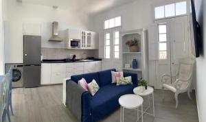 a living room with a blue couch and a kitchen at Meriga in Agulo