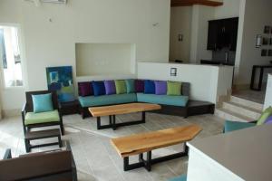 a living room with a couch and a table and chairs at Sky Beach Club Villa Waterfall 2 home in Governorʼs Harbour