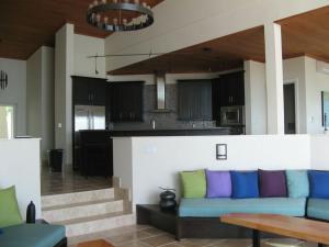a living room with a blue couch and a kitchen at Sky Beach Club Villa Waterfall 2 home in Governorʼs Harbour