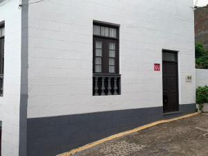 a white brick building with two windows and a door at Meriga in Agulo