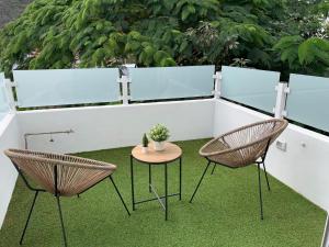 two chairs and a table on a patio with grass at Meriga in Agulo