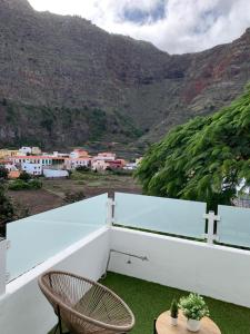 a balcony with two chairs and a table and a mountain at Meriga in Agulo
