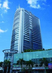 un edificio alto con palmeras delante en Yihe Hotel Ouzhuang, en Guangzhou