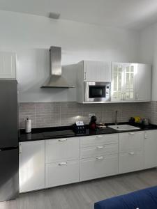 a kitchen with white cabinets and a black refrigerator at Meriga in Agulo +20 photos