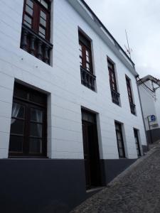 a white building with red windows on a street at Meriga in Agulo