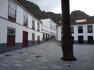 an empty street with white buildings and a tree at Meriga in Agulo