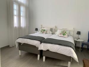 a white bedroom with a large bed with pillows at Meriga in Agulo