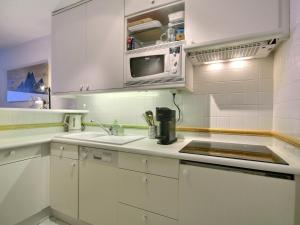 a white kitchen with a sink and a microwave at Appartement La Plagne, 3 pièces, 6 personnes - FR-1-455-244 in La Plagne Tarentaise