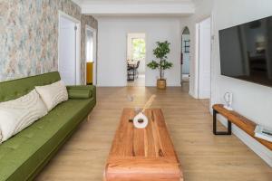 sala de estar con sofá verde y mesa de centro de madera en Moderno apartamento céntrico en Santander