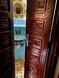 une porte ouverte menant à une salle de bains pourvue de toilettes. dans l'établissement Riad Nezha avec jacuzzi et au cœur de Marrakesh, à Marrakech 53 autres photos