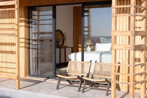 a bedroom with a bed and two wicker chairs at La Tour d'Eole in Dakhla