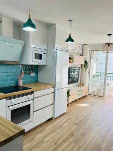 a kitchen with white appliances and blue tiles at APARTAMENTO NUEVO CÉNTRICO en PRIMERA Línea de playa con vistas al Mar, Piscina, aire acondicionado y wifi in Peñíscola