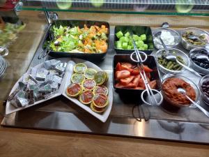 a buffet with several trays of food on a table at Sofia Palace Hotel by HMG in Sofia