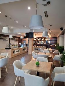 a restaurant with tables and chairs and a kitchen at Sofia Palace Hotel by HMG in Sofia