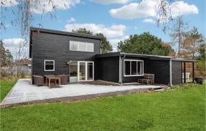 a black house with a patio and a yard at Amazing Home In Hjby With Wifi in Højby