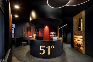 a black and red lobby with a round exhibit with the number at Therme 51° Hotel Physio & Spa in Leukerbad