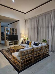 a living room with a couch and a television at Roemah Uli Cirebon in Cirebon