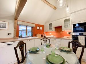 a kitchen with a table with green plates on it at Bushton Barn in Royal Wootton Bassett