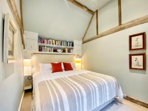 ein Schlafzimmer mit einem Bett und einem Bücherregal in der Unterkunft Bushton Barn in Royal Wootton Bassett