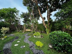 un jardín con un sendero rocoso y un banco en Roemah Uli Cirebon, en Cirebon