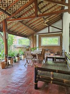 a patio with a table and chairs and a wooden ceiling at Roemah Uli Cirebon in Cirebon