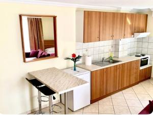 a kitchen with a table and a sink and a mirror at Omonias Apartments in Kavála